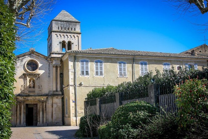 A historic building with a bell tower, a round window, and a gate. 1