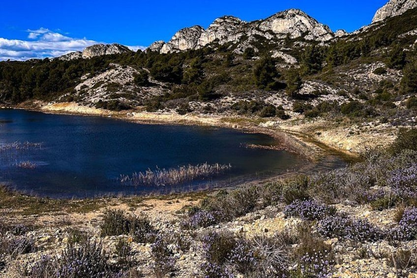 A lake surrounded by mountains, with sparse vegetation and rocky terrain. 3