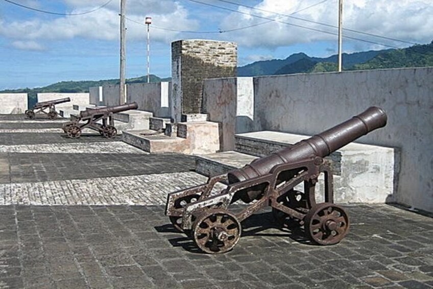 Eine Kanone auf einem Kopfsteinpflaster vor einer Bergkulisse. 2