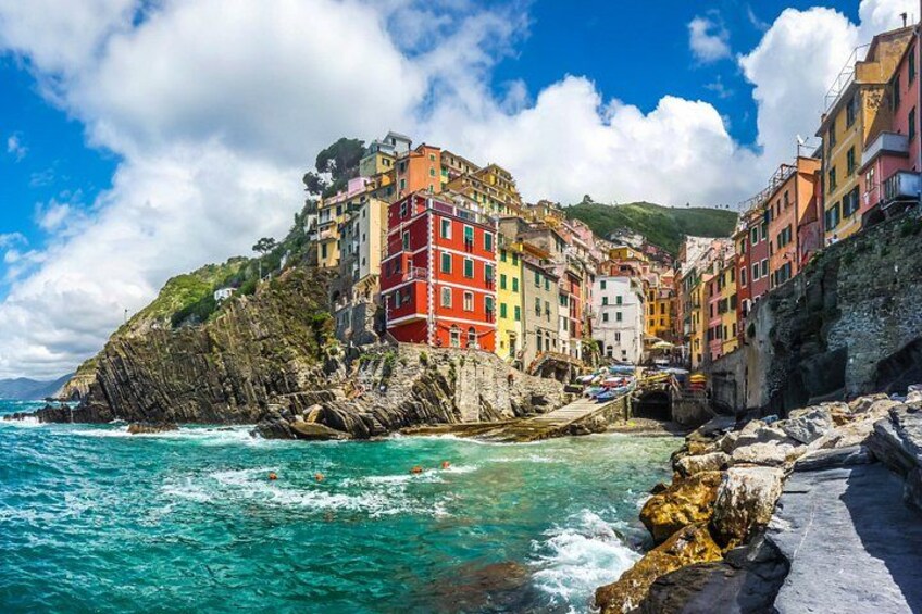 Une ville côtière aux bâtiments aux couleurs vives, aux falaises rocheuses et aux eaux turquoise. 2