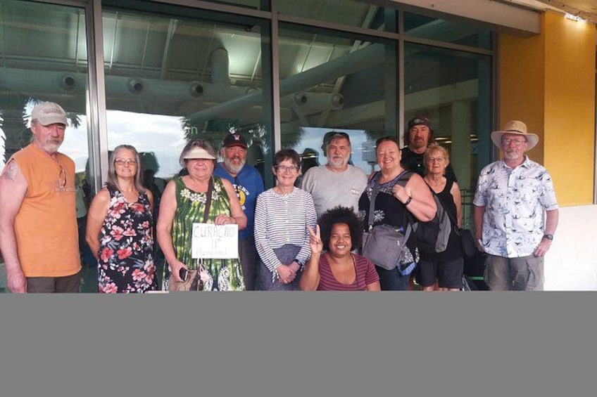A group of people standing in front of a building with large windows. 3