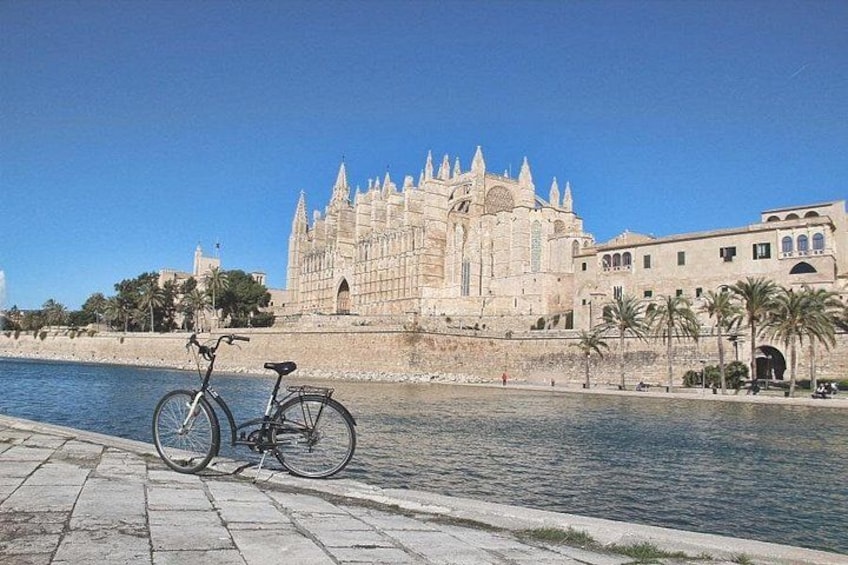 Une cathédrale historique au bord d’une rivière, avec un vélo à proximité. 5