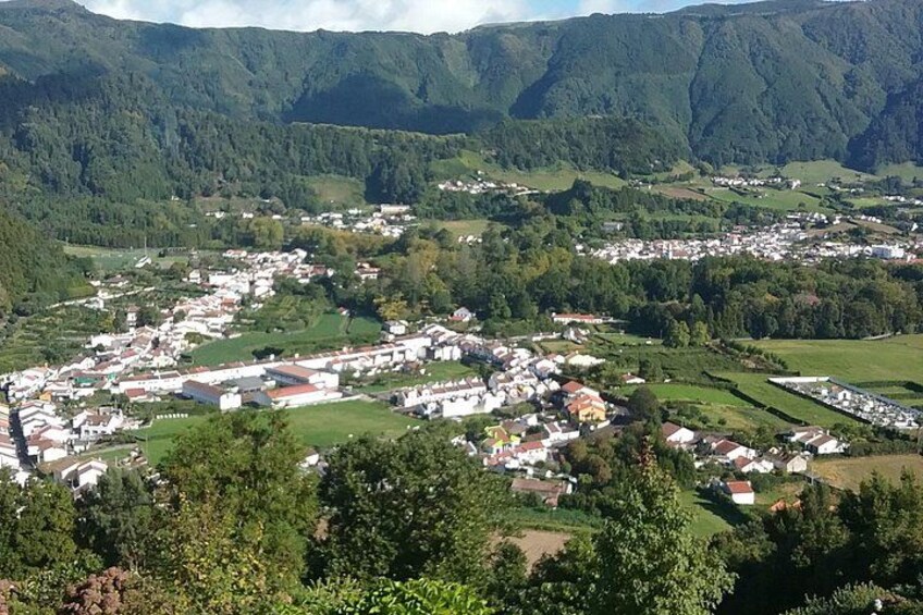 A town nestled in a valley with surrounding hills, surrounded by greenery. 2