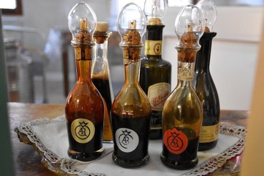 Several bottles of liquid on a table with a lace doily. 1