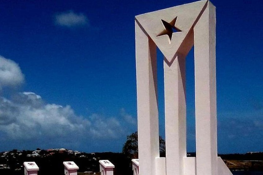 Un monumento blanco con una estrella en la parte superior, sobre un cielo azul despejado. 1