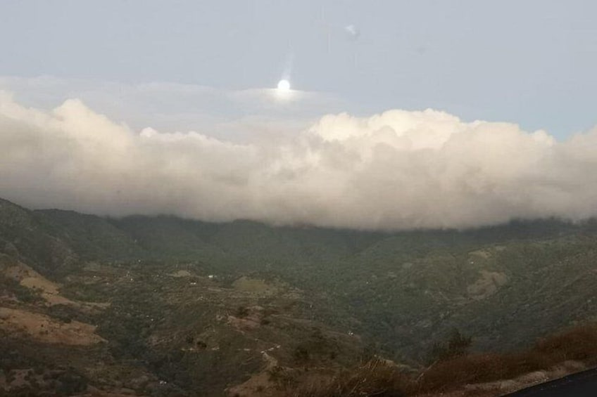 A mountainous landscape with a valley and a cloudy sky. 2