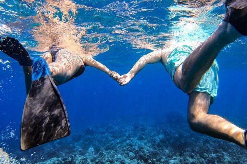 Two people scuba diving underwater, holding hands. 5