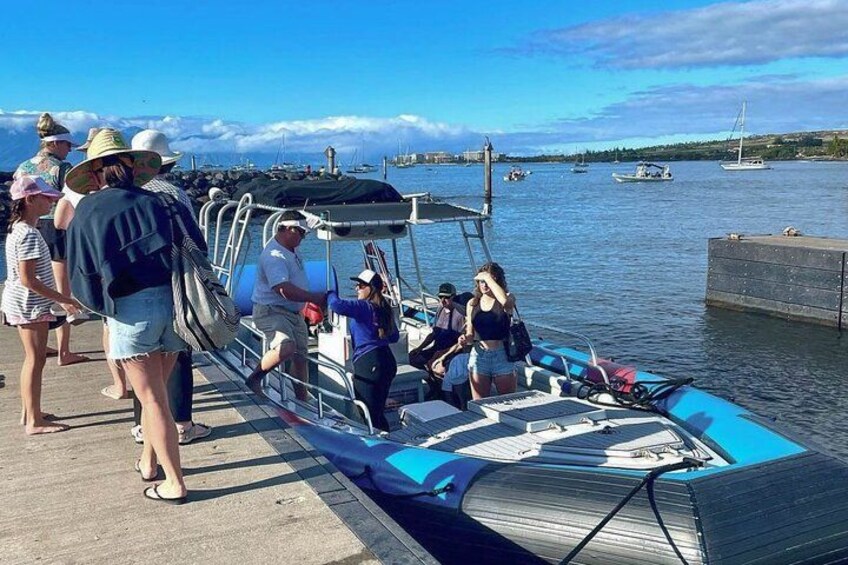 Un grupo de personas en un bote amarrado a un muelle, con cielo despejado y agua tranquila. 5