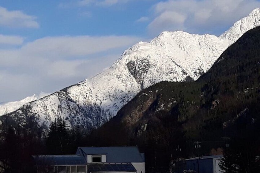 A snow-covered mountain range with a small building in the foreground. 5