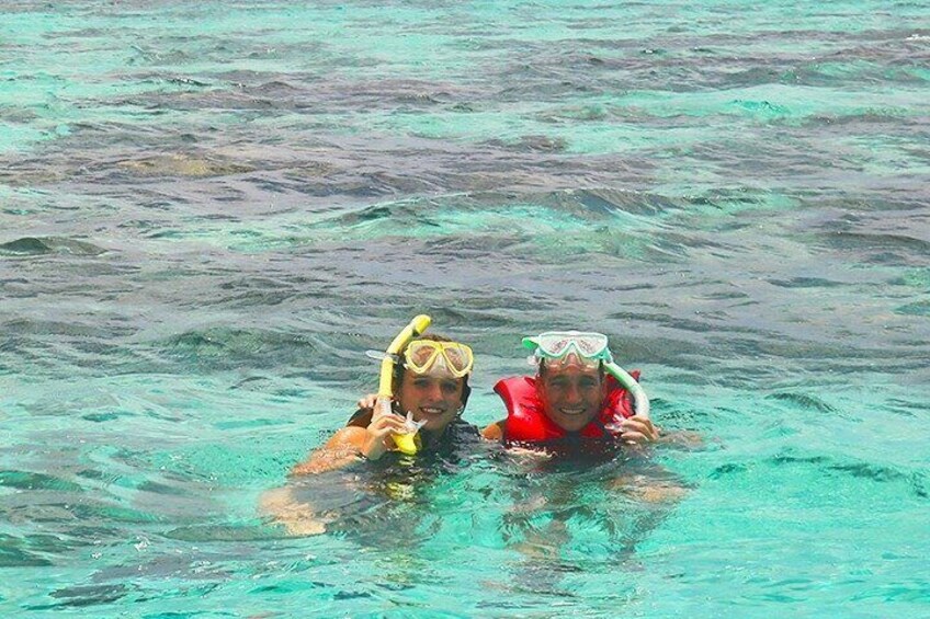Dos personas haciendo snorkel en aguas turquesas y cristalinas. 1