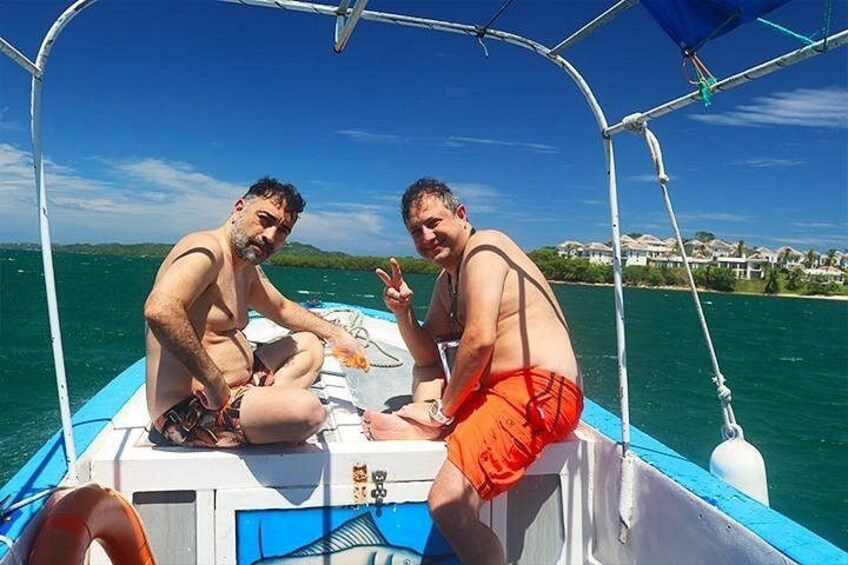 Dos hombres en un bote bajo un cielo azul despejado y aguas tranquilas. 3