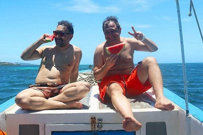 Dos personas en un bote, una sosteniendo una rebanada de sandía y la otra, gafas de sol. 5