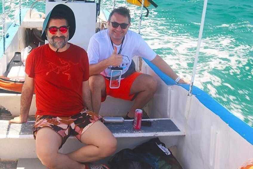 Dos personas en un bote, con una lata de bebida y una bolsa. 3