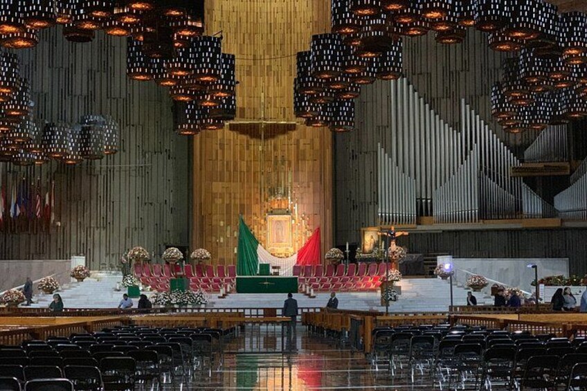 Ein Auditorium mit Reihen von Stühlen, einer Bühne mit Rednerpult und einer großen Orgel im Hintergrund. 1