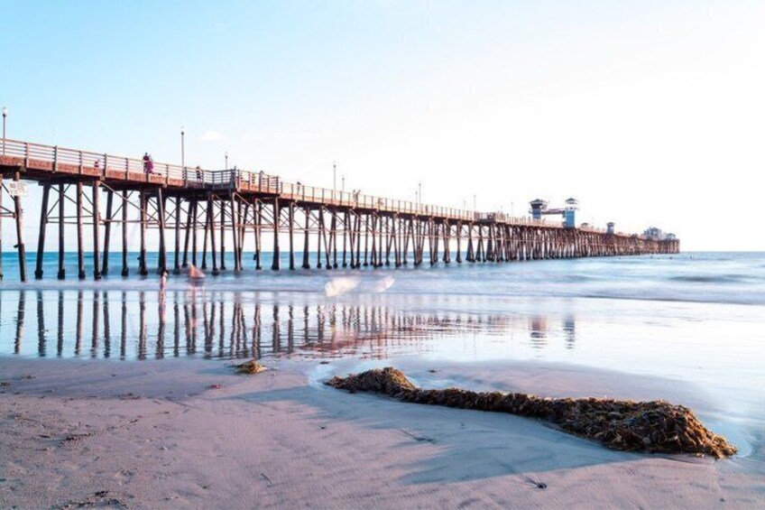 A pier extending into calm waters with a sandy beach in the foreground. 5