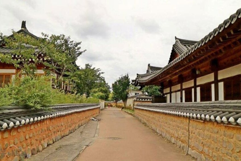 A traditional Korean courtyard with stone walls and wooden buildings. 3