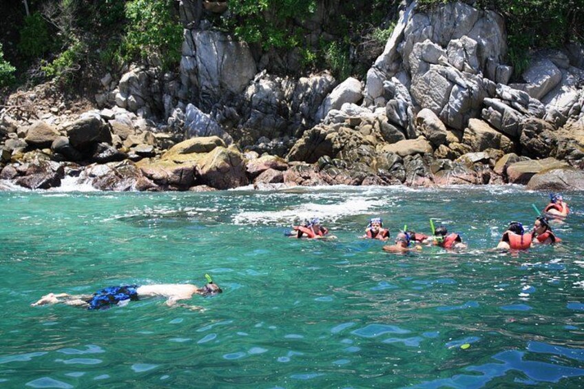 Personas nadando en aguas cristalinas cerca de acantilados rocosos. 1