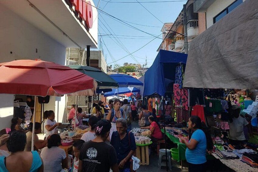 Een levendige markt met mensen die winkelen en verkopers die waren aanbieden. 3