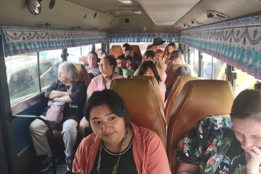 A bus interior with passengers seated. 3