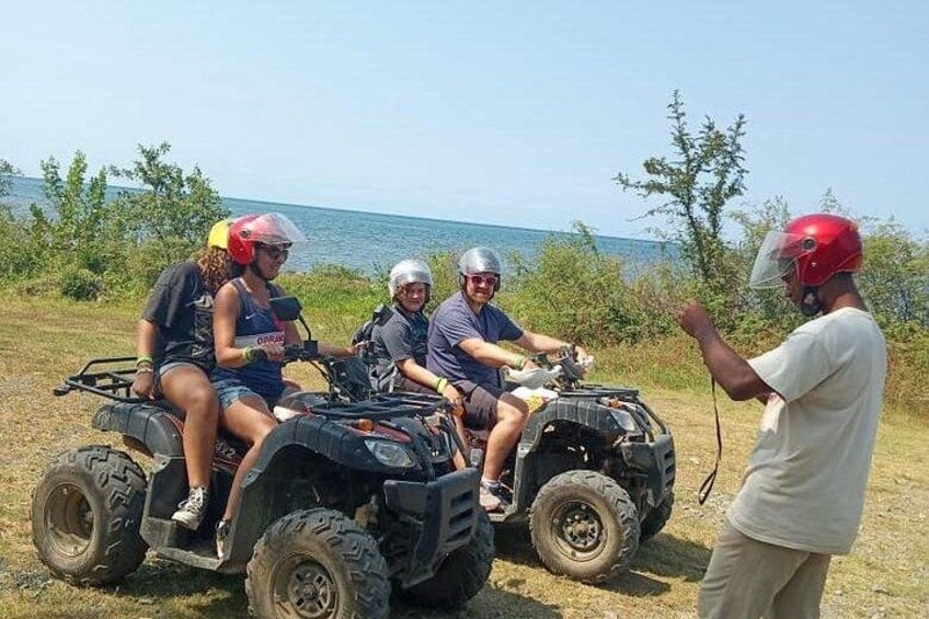 Four people on ATVs with a guide standing nearby. 3
