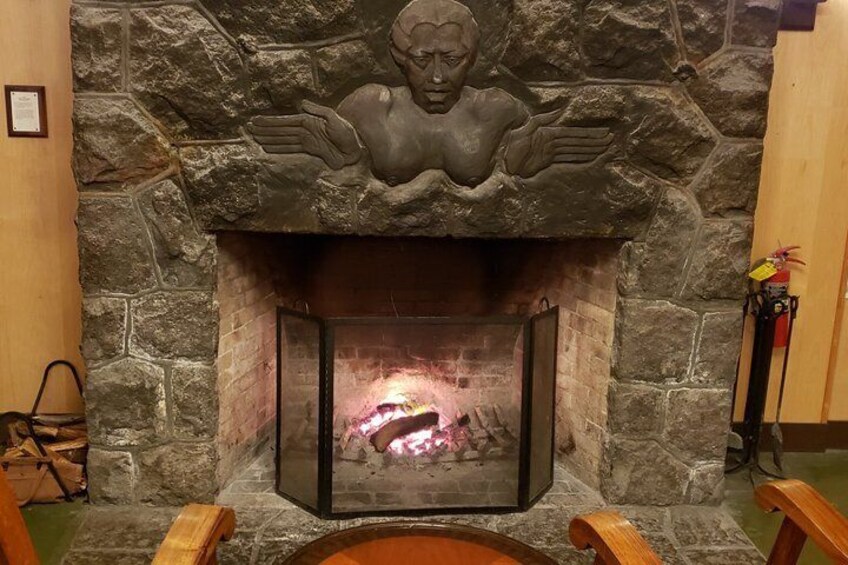 A stone fireplace with a decorative relief above it. 4
