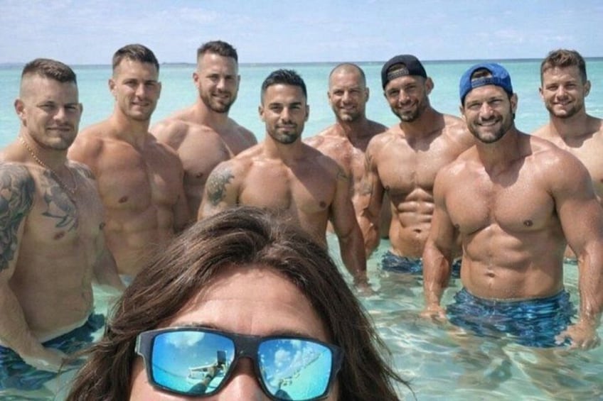 Un grupo de hombres musculosos en traje de baño en la playa. 2