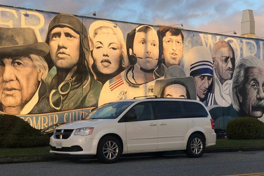 En hvid varevogn parkeret foran en mural med historiske personer og teksten '2. VERDENSKRIG'. 2