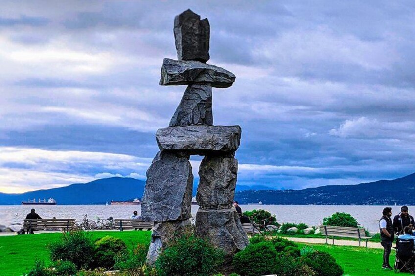 Un totem dans un parc, avec un lac et des montagnes en arrière-plan. 4