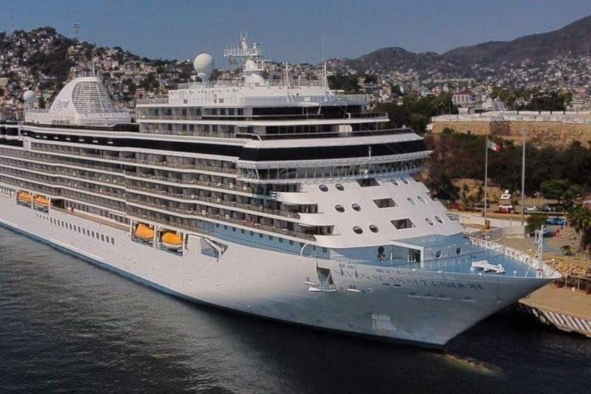Un grand navire de croisière était amarré dans un port, avec une vue sur la ville en arrière-plan. 1
