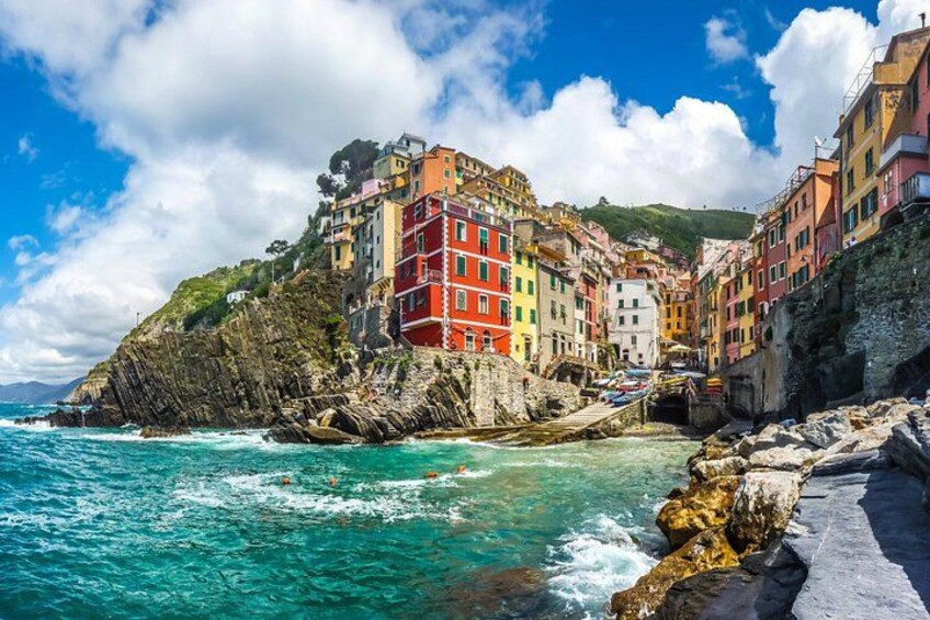 Une ville côtière aux bâtiments colorés, aux falaises rocheuses et à la mer turquoise. 5