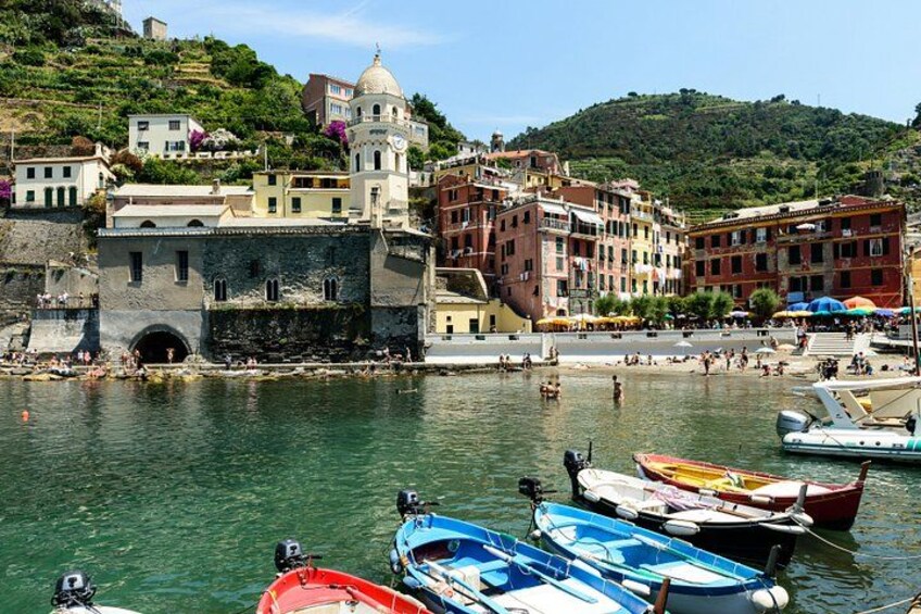 Une ville côtière où des bateaux sont amarrés, avec des bâtiments historiques et une colline en arrière-plan. 4