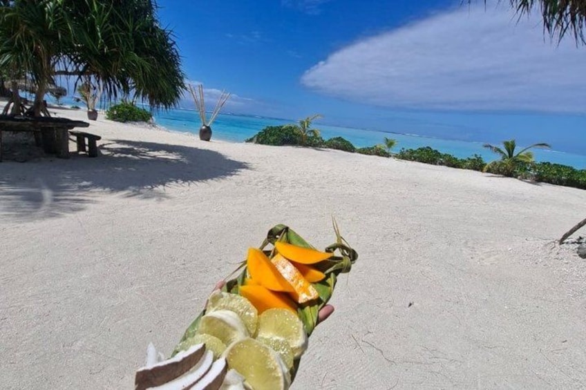 A beach with a lounge chair, a table, and a palm tree. 4