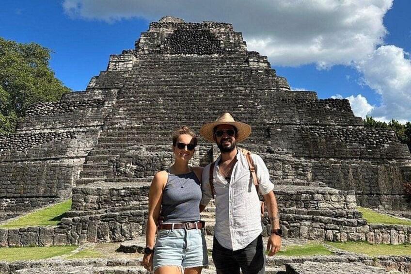 Una gran y antigua estructura piramidal con dos personas de pie frente a ella. 5