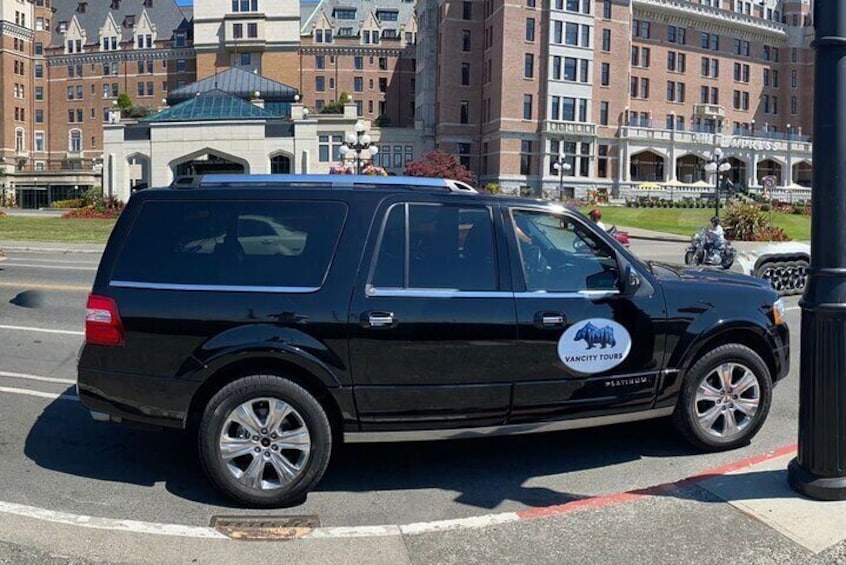 Un fourgon noir, orné d’un logo et d’une inscription sur le côté, est garé dans une rue. 2