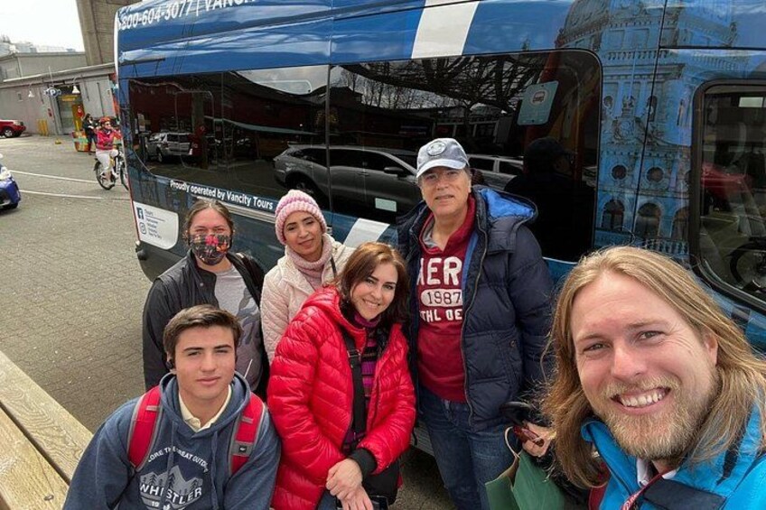 Un grupo de personas de pie frente a un autobús turístico. 2
