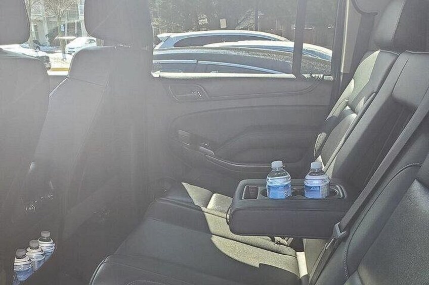 Asiento trasero de un coche con dos botellas de agua en el portavasos. 3