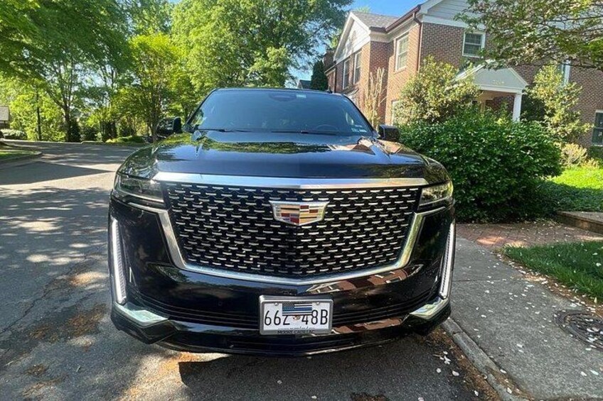 Un SUV Cadillac negro estacionado en una calle residencial. 1