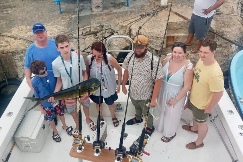 Eine Gruppe von Personen auf einem Boot, die einen Fisch halten. 1