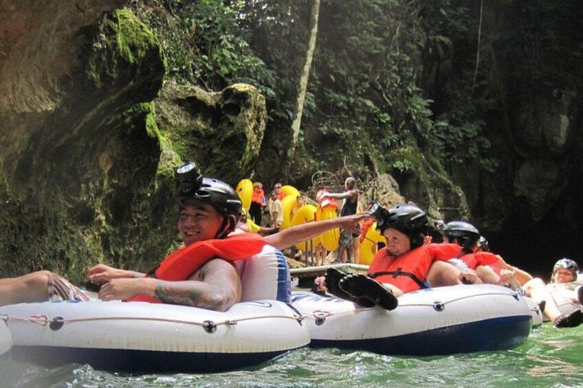 People rafting in inflatable boats with helmets and life jackets. 1