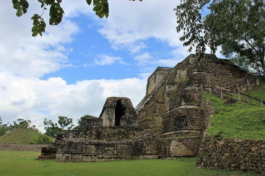 Ancient ruins with a large stone structure, a staircase, and a grassy area. 2