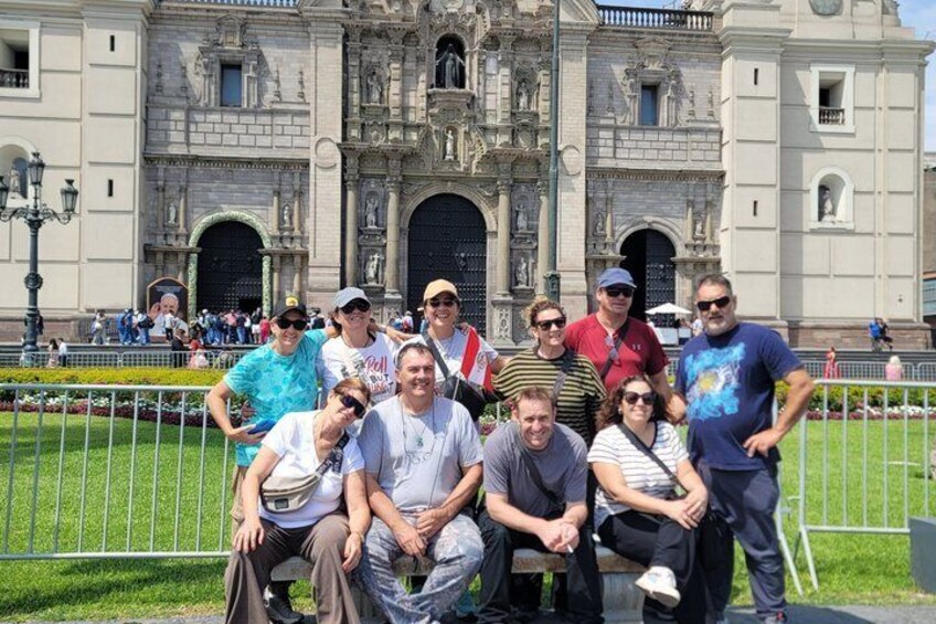 A group of people posing in front of a historic building with ornate architecture. 4