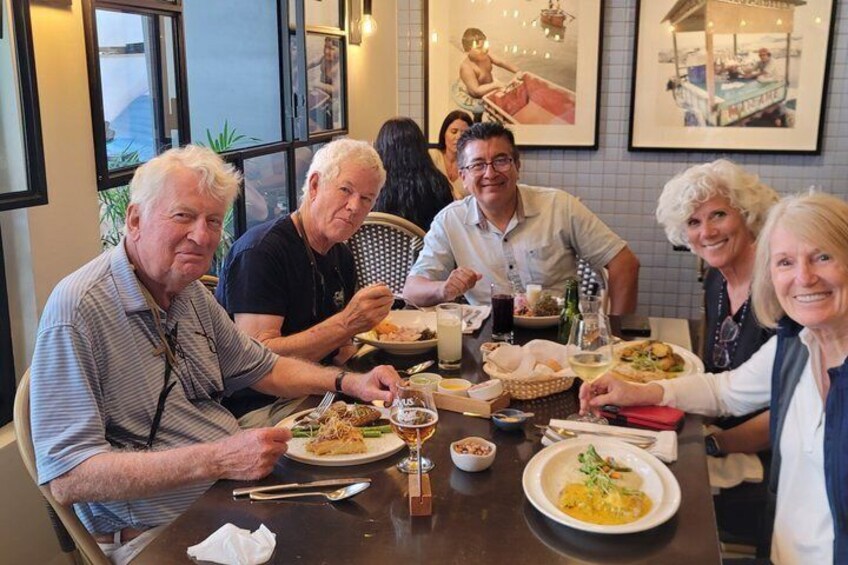A group of people dining at a restaurant with various dishes on the table. 3