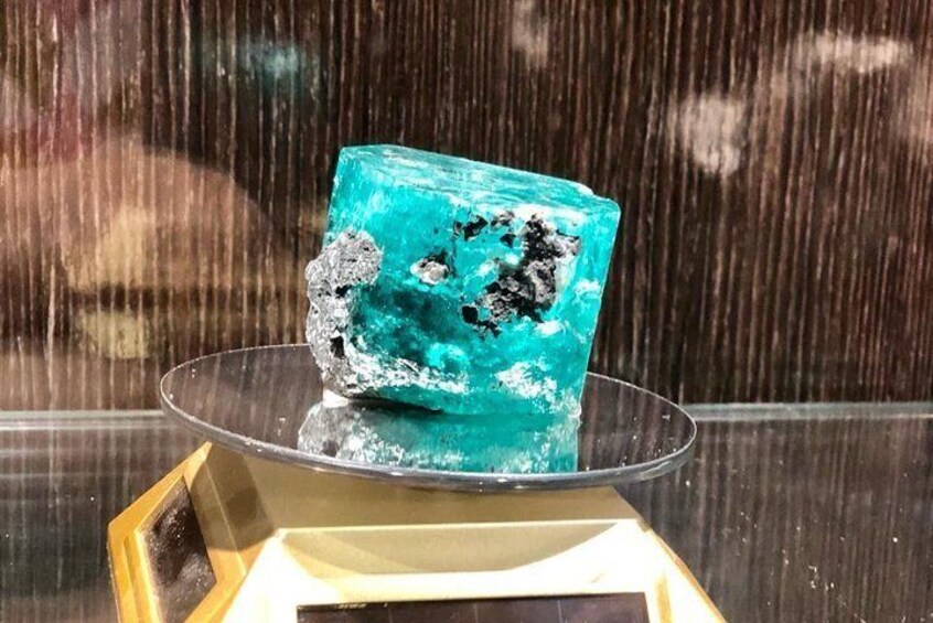 A blue crystal cube on a glass stand. 3