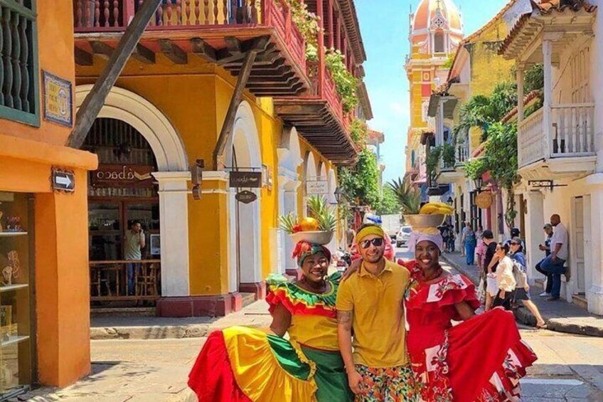 A street with colorful buildings, a person in a yellow shirt, and another in a red and green outfit. 2