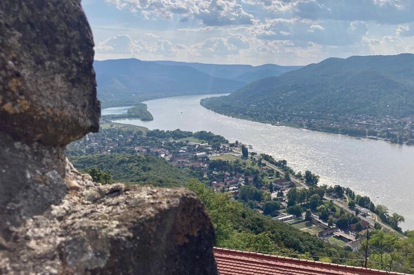 Ein See, umgeben von Bergen, einer Stadt und einer Steinstruktur. 4