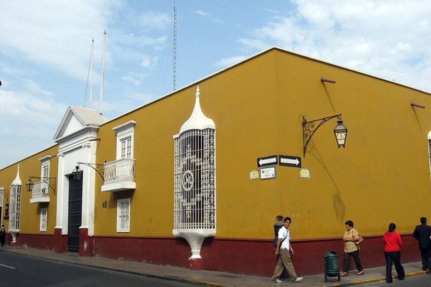A yellow building with white balconies, a street lamp, and a person walking. 3