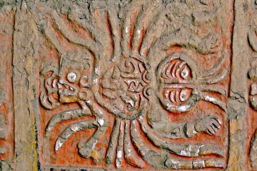 A textured surface with carved figures, possibly ancient or historical. 4