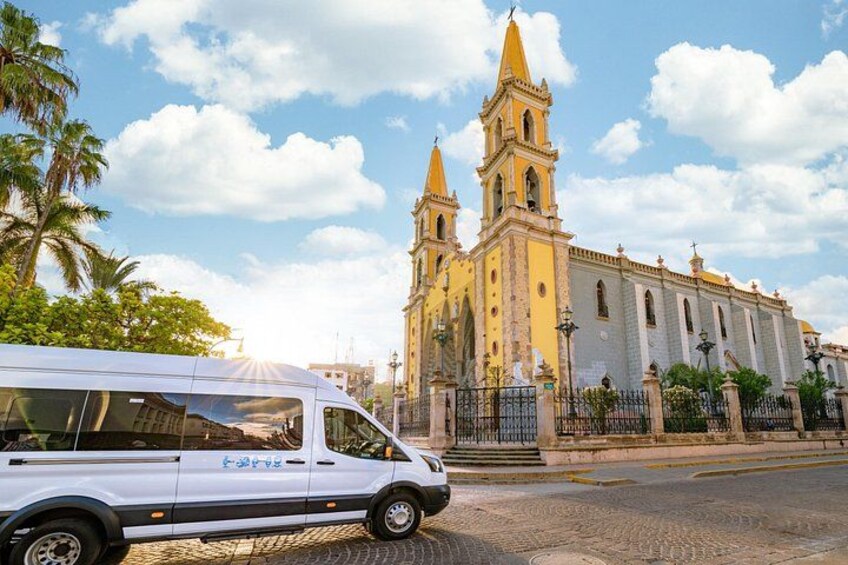Un fourgon blanc était garé devant une grande église jaune et blanche, dotée de deux tours. 3