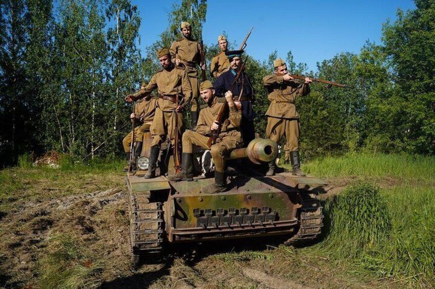 Soldiers in uniform on a military tank in a wooded area. 5