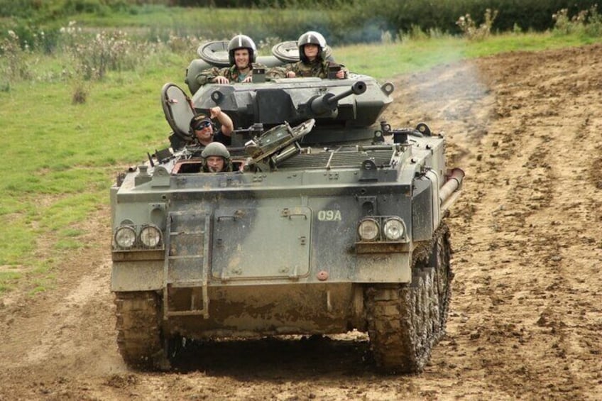 A military vehicle with soldiers driving on a muddy road. 1